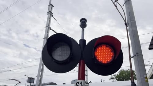 Uma luz vermelha está acesa em um cruzamento ferroviário