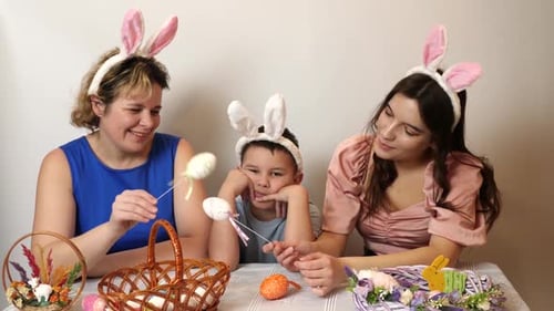 30 1. Mother, daughter and son are looking at Easter eggs. Celebrating Easter in the family. Easter