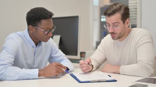 Young Mixed Race People Doing Paperwork in Office