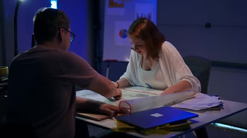 Rack Focus, d'une jeune femme concentrée et positive parlant en examinant un plan architectural à