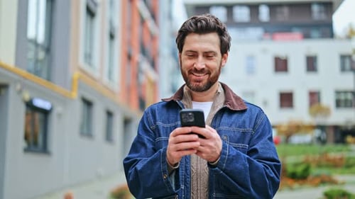 Happy Man Using Phone Cheerfully Outdoors