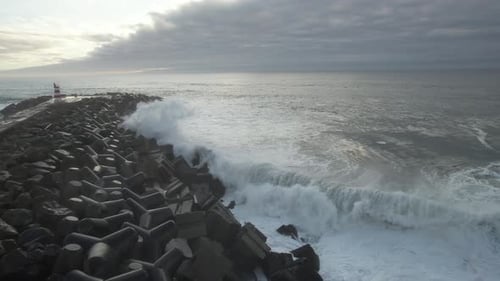 Lighthouse on Rocky Coast with Crashing Ocean Waves