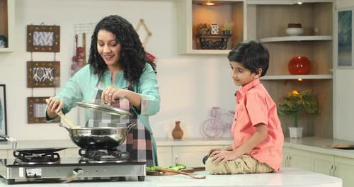Woman Cooking with Child in Modern Kitchen