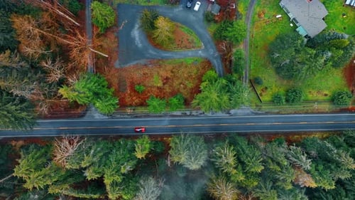 Red car drives by the highway in the beautiful countryside.