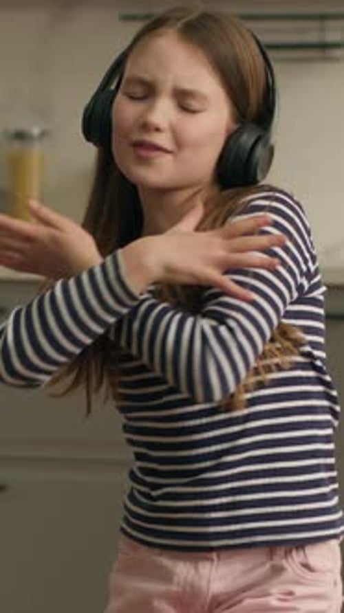 Caucasian Energetic Little Girl Child Kid Wearing Modern Headphones Earphones Dancing Listening