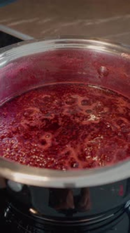 Raspberry Jam Simmering in Steel Pot on Stove