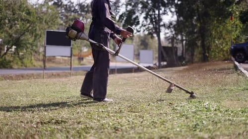 Grass Being Cut By Unrecognisable Man in Thai Village