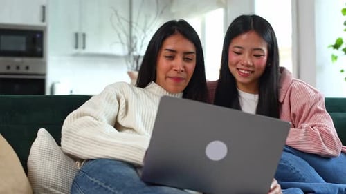 Asian Women Friends Using Laptop Together on Sofa