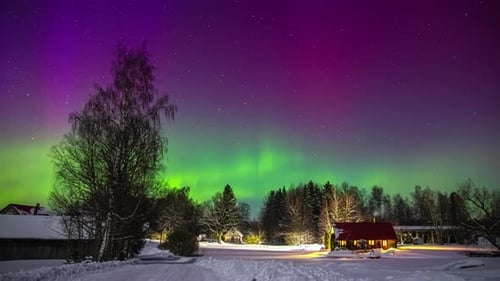 Time-lapse shot of beautiful colors illuminating sky with stars at night during aurora borealis outd