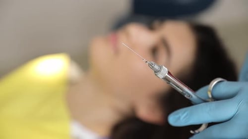 Woman Getting Injection in Facial Area From Dentist