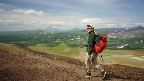 Adventurous Hiker Walking Mountain Trail on Sunny Day