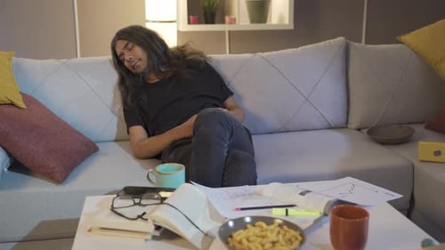 Man Lying Asleep on Couch in Messy Living Room
