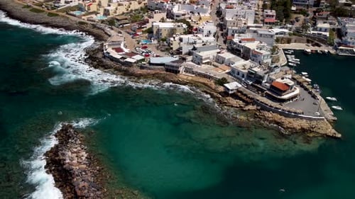 Large waves rolling on rocks at the coastline of Sisi at Crete. Drone panning tilt shot
