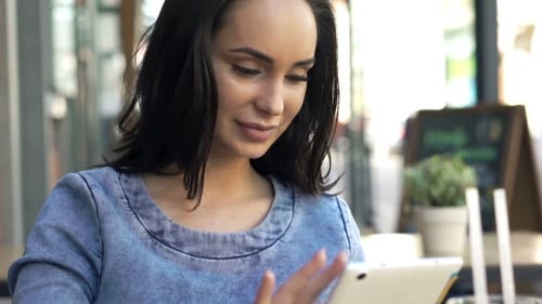 Attractive young woman with tablet enjoying coffee shop lifestyle in the city