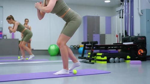 Leg Flexibility Exercise with Gym Instructor Watching in Fitness Studio