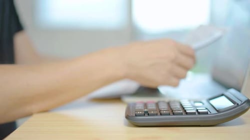 Close up man hand press calculator to calculate income expenses and plans for spending money on home