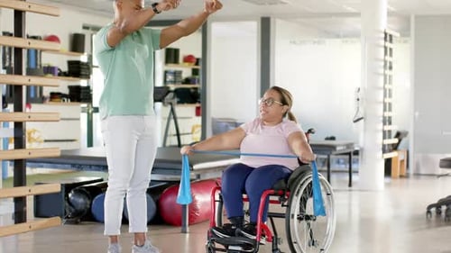 Physical Therapist Assists Woman with Resistance Band
