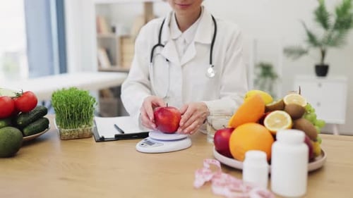 Woman Weighing an Apple in Bright Doctor's Office