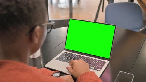 Back View of African Man Using Laptop with Green Screen