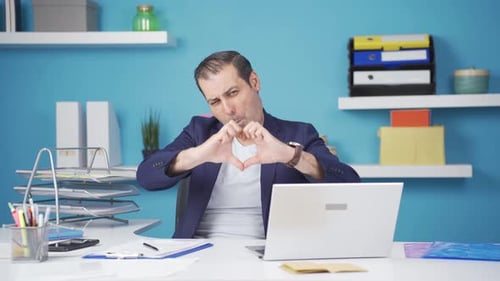 Man Makes Heart Shape at Office Desk