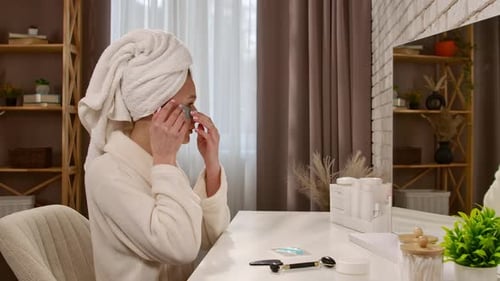 Woman Applies Eye Masks at Vanity Table