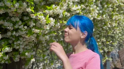 Teen Smells Flowers in Springtime Garden