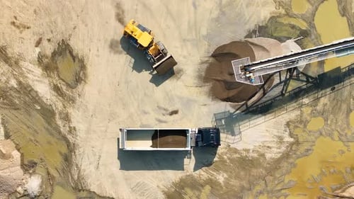 Activity in sand quarry with machinery and truck in operation
