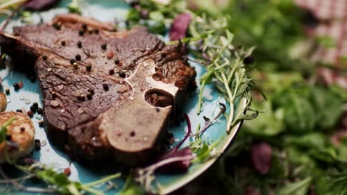 Steak d'os grillé tournant sur la table avec de la verdure fraîche