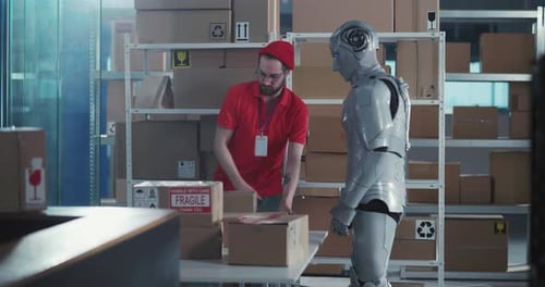 Caucasian Post Office Worker Cooperating with Robotic Future Employee Carrying Heavy Cardboard