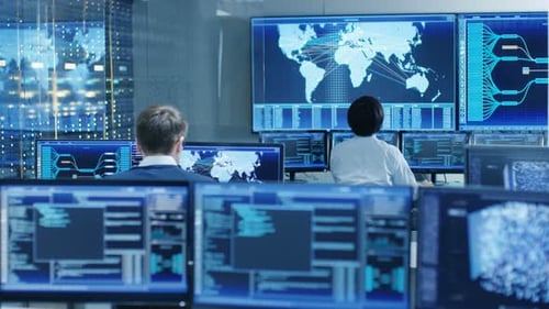 Na sala de controle do sistema, o operador e o administrador sentados em suas estações de trabalho com vários D