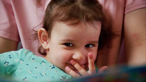 Cute Infant with Mother Reading Book