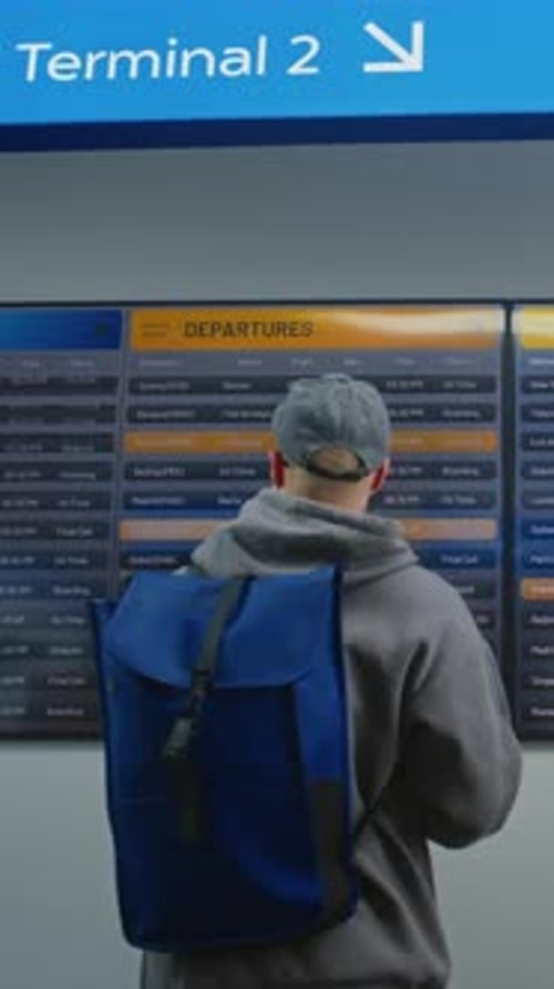 Travelers Check Flight Information on Airport Departure Board