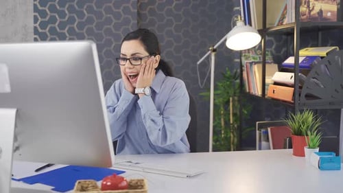 Business woman working in office rejoices.