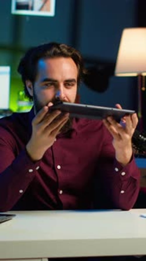 Man Using Tablet for Video Call at Desk