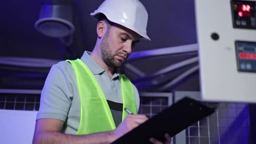 Electrical Engineer Inspects Switchboard and Control Panel in Server Room