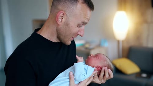 Affectionate Father Holds Adorable Newborn Baby Indoors