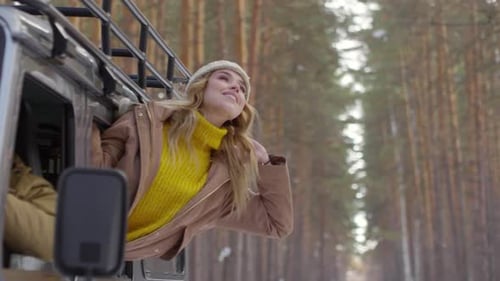 Woman Enjoys Winter Scenery From Moving Vehicle