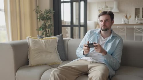 Young Adult Man Playing Video Game on Couch