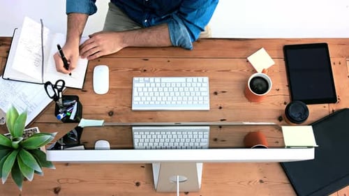 4K-Videomaterial aus der Vogelperspektive eines Geschäftsmannes bei der Arbeit an seinem Schreibtisch in einem Büro