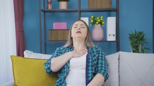 Une jeune femme essoufflée respire fort.