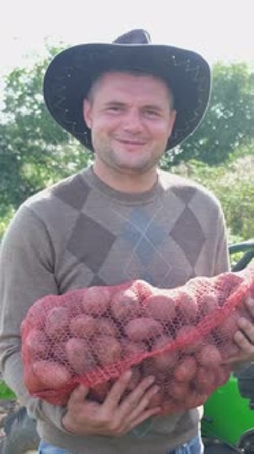 Man Holding a Bag of Harvested Potatoes