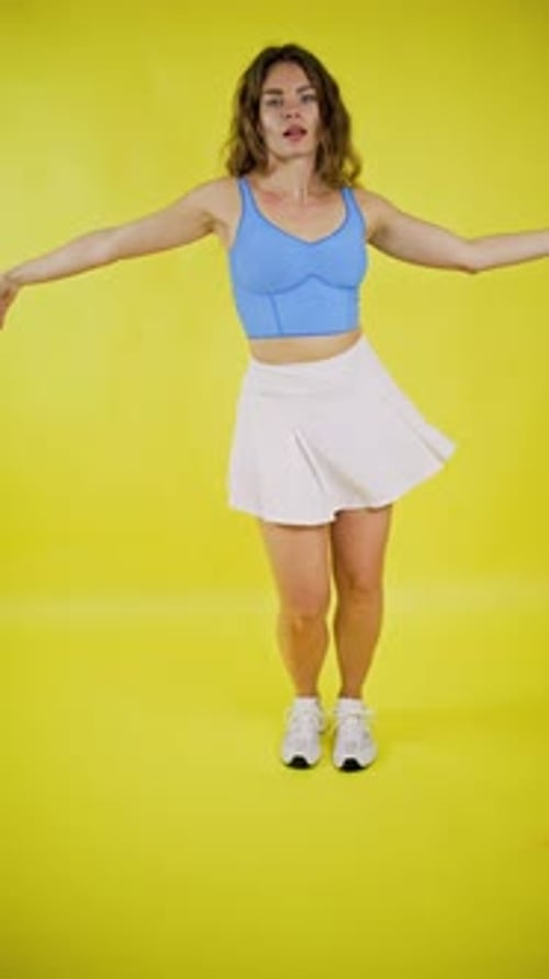 Energetic Woman Dancing on Yellow Background