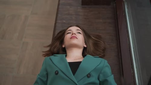 Woman Relaxing on Wooden Floor Looking Upward