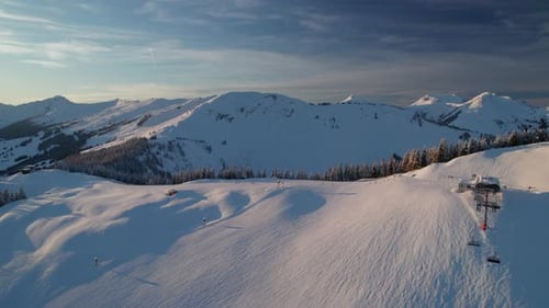 Skiers Over Ski Lift Kohlmaisbahn II Valley Station in Saalbach-Hinterglemm, Austria. Aerial Drone S