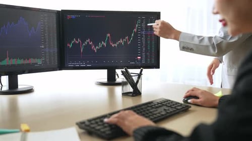 Business Women Analyze Stock Data in Modern Office