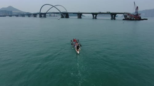 Dragon Boat team rowing to the pace of an onboard Drummer, Aerial view.