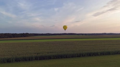 Aerial View of Hot Air Balloon at Dusk Above Forests
