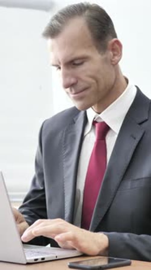 Businessman Working On Laptop in Office, Vertical Video