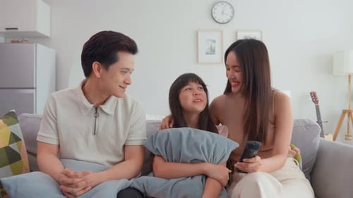 Happy Family Watching TV Together on Couch