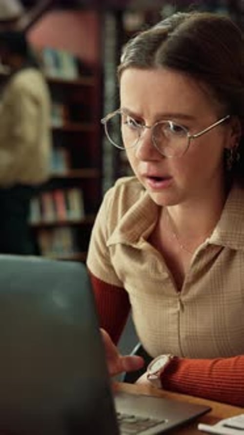 Student, woman and stress in library with laptop, college grade or disappointed for assessment fail